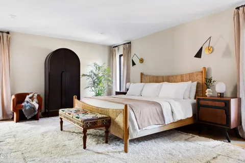 a bedroom with a bed and a potted plant