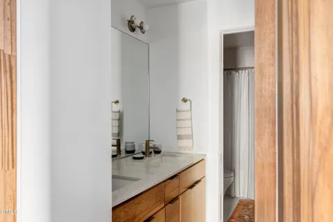 a bathroom with a sink vanity granite and a mirror