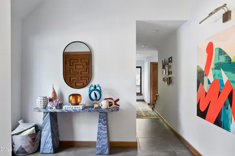 a room with lots of white furniture and a wooden floor