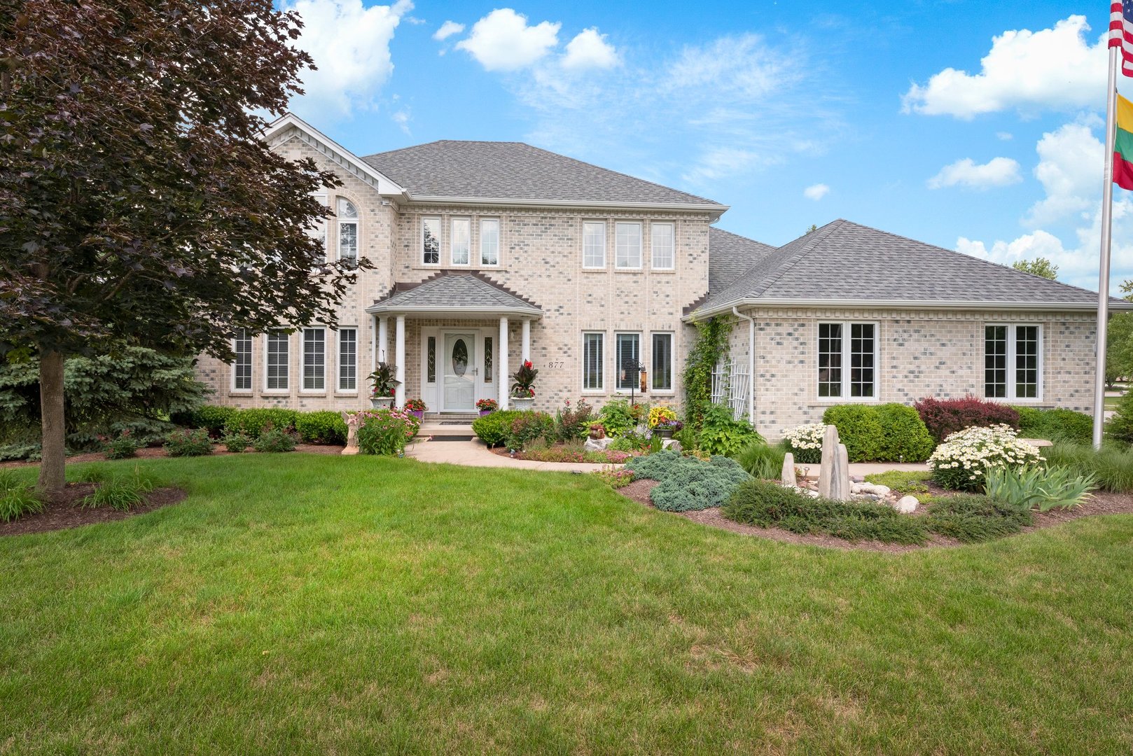 a front view of a house with yard and green space