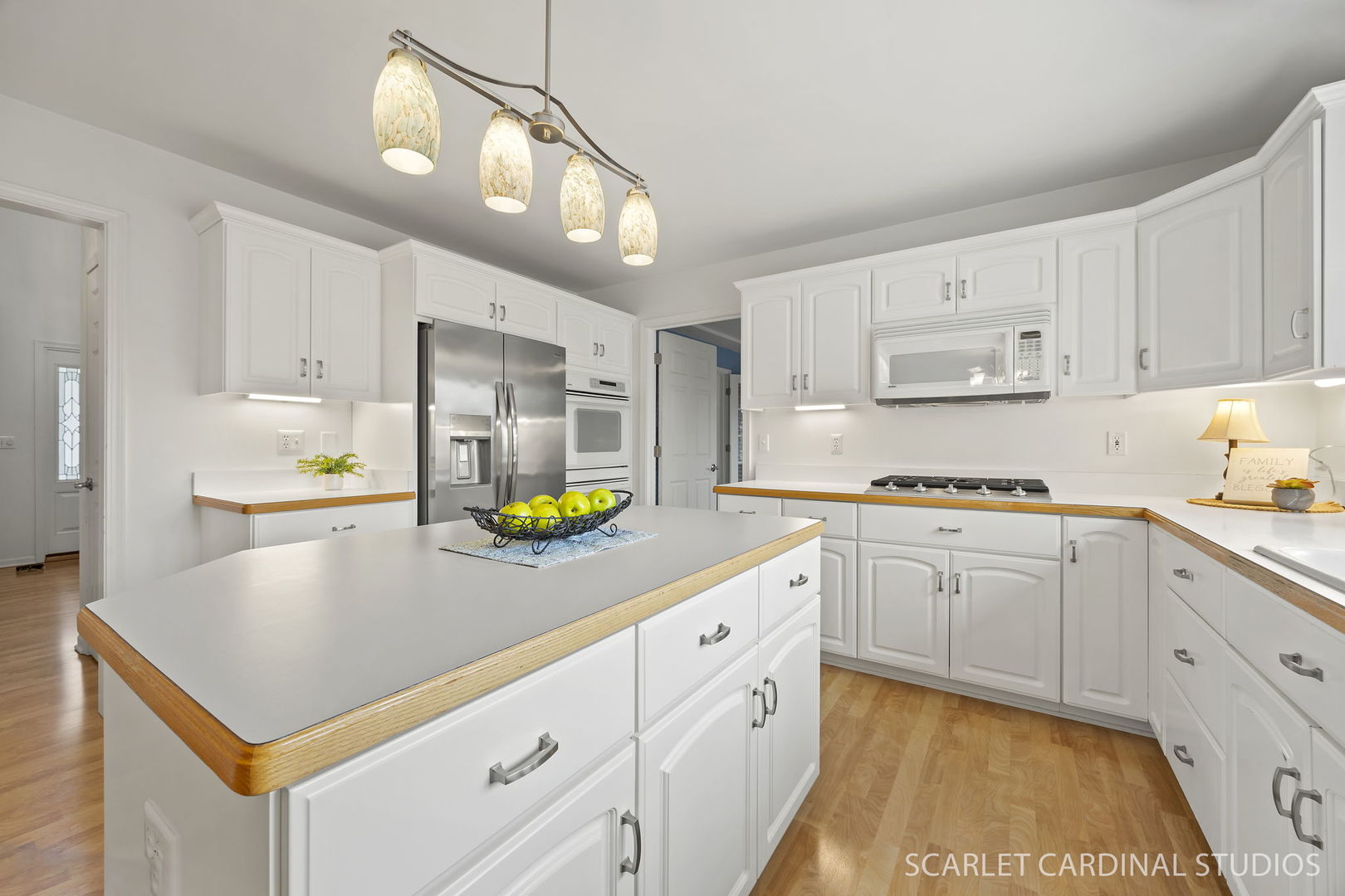 877 Elm Street Sugar Grove, IL 60554 - Photo 8 of 38 a kitchen with kitchen island granite countertop a stove a sink a refrigerator and white cabinets with wooden floor