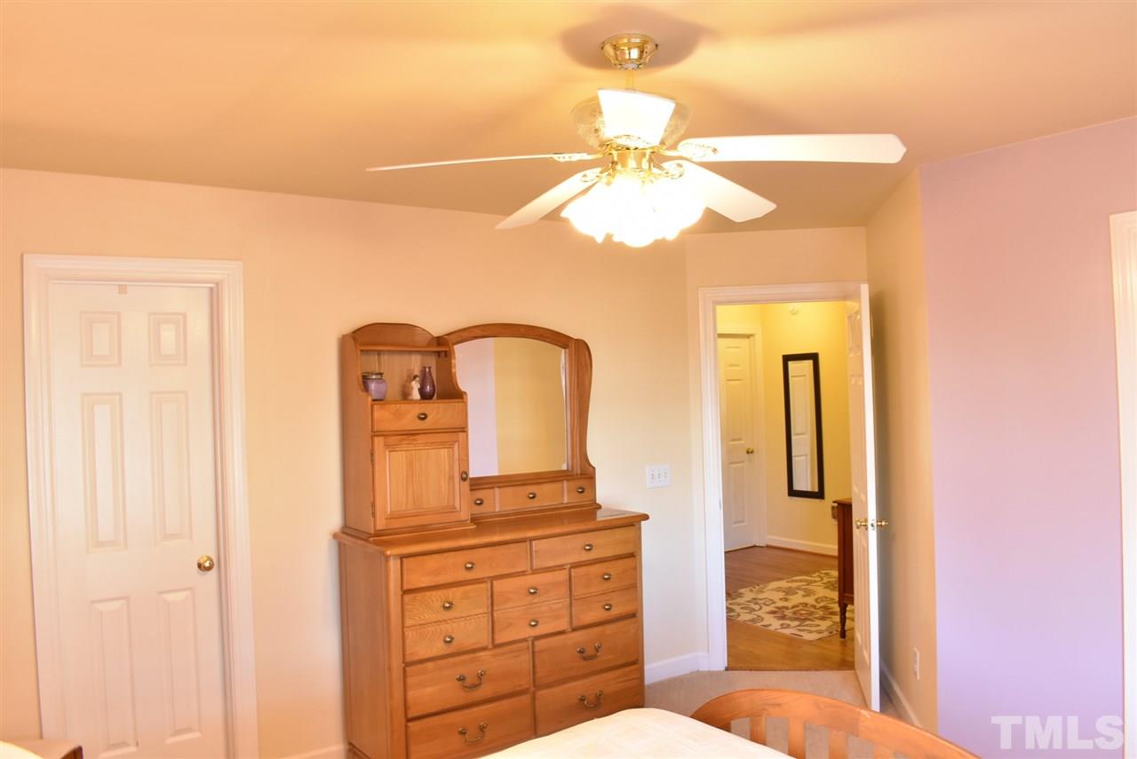 4629 Mill Rock Lane Raleigh, NC 27616 - Photo 14 of 30 a bedroom with a bed and a chandelier