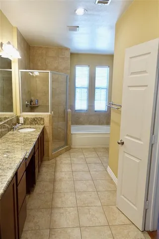 a spacious bathroom with a granite countertop sink a toilet and a shower