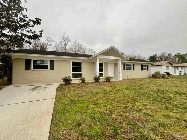 a view of an empty room with a window and kitchen