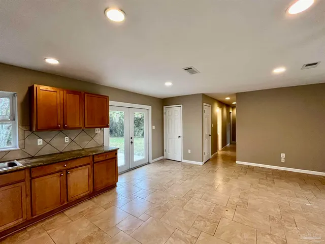 en empty room with a chandelier fan and table