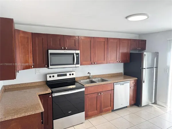 a kitchen with a stove a sink and a refrigerator