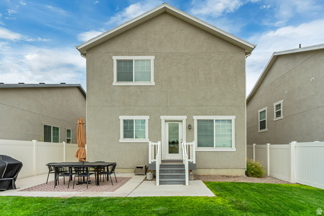 7693 West Mount Elinor Road Magna, UT 84044 - Photo 28 of 33 Rear stucco exterior with white trim windows and a glass-paneled door