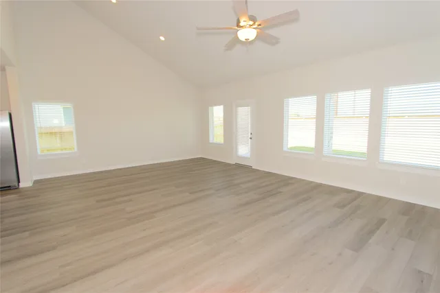 an empty room with wooden floor and window