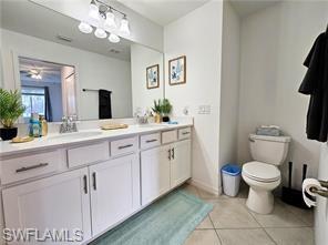 6039 Ellerston Way Avenue, Unit 2017 Immokalee, FL 34142 - Photo 11 of 34 a bathroom with a toilet sink and mirror