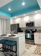 6039 Ellerston Way Avenue, Unit 2017 Immokalee, FL 34142 - Photo 3 of 34 a kitchen with stainless steel appliances kitchen island granite countertop a stove a sink a microwave and a refrigerator