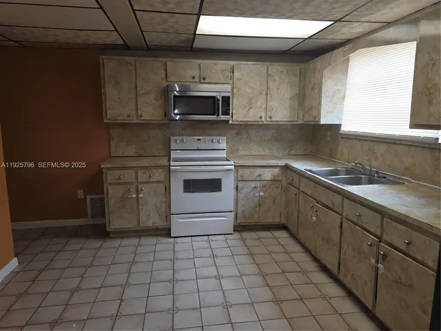 a kitchen with a stove sink and cabinets