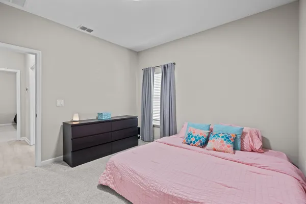 a bedroom with a large bed and a chandelier