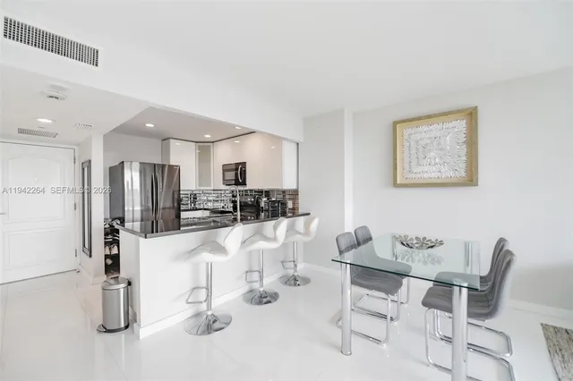 a kitchen with stainless steel appliances kitchen island granite countertop a refrigerator and cabinets