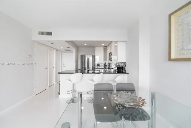 a view of a living room and kitchen with stainless steel appliances