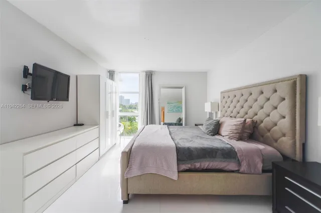 a bedroom with a large bed and a flat screen tv