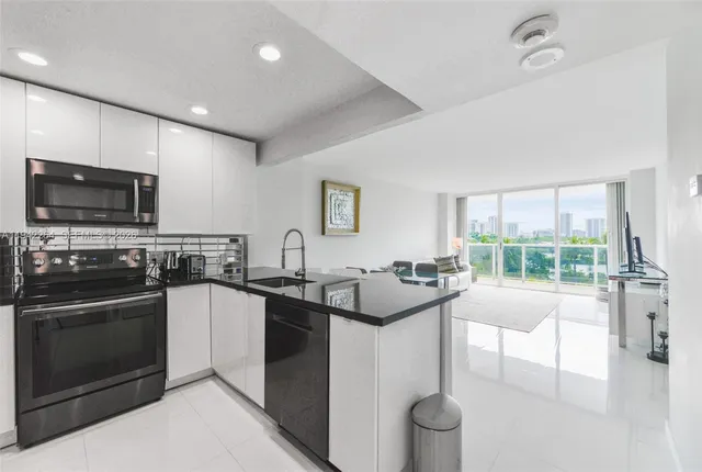 a kitchen with stainless steel appliances granite countertop a sink stove and microwave