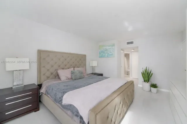 a bedroom with a bed and a potted plant