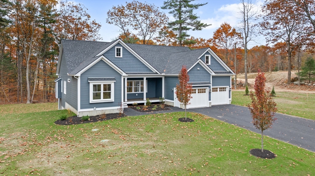 a front view of a house with a yard and trees
