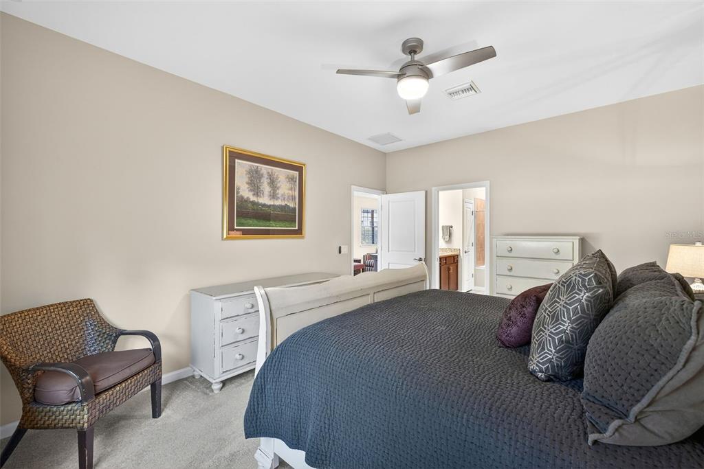 5821 Mayflower Way Ave Maria, FL 34142 - Photo 18 of 36 a living room with a bed furniture chandelier and a window