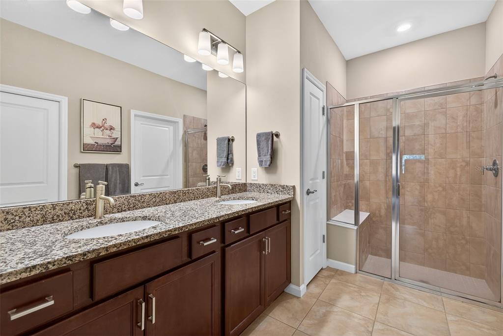 5821 Mayflower Way Ave Maria, FL 34142 - Photo 19 of 36 a bathroom with a granite countertop sink a mirror and a shower