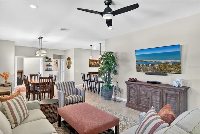 a living room with furniture a chandelier and a flat screen tv