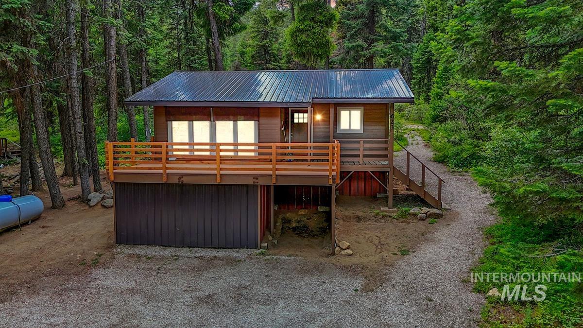623 West Mountain Road Cascade, ID 83611 - Photo 1 of 1 Rustic home featuring a forest view, a metal roof, and stairs
