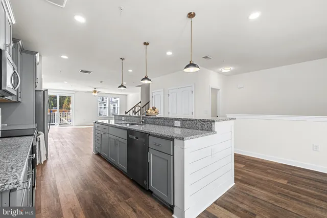 a kitchen with a sink stove and wooden floor
