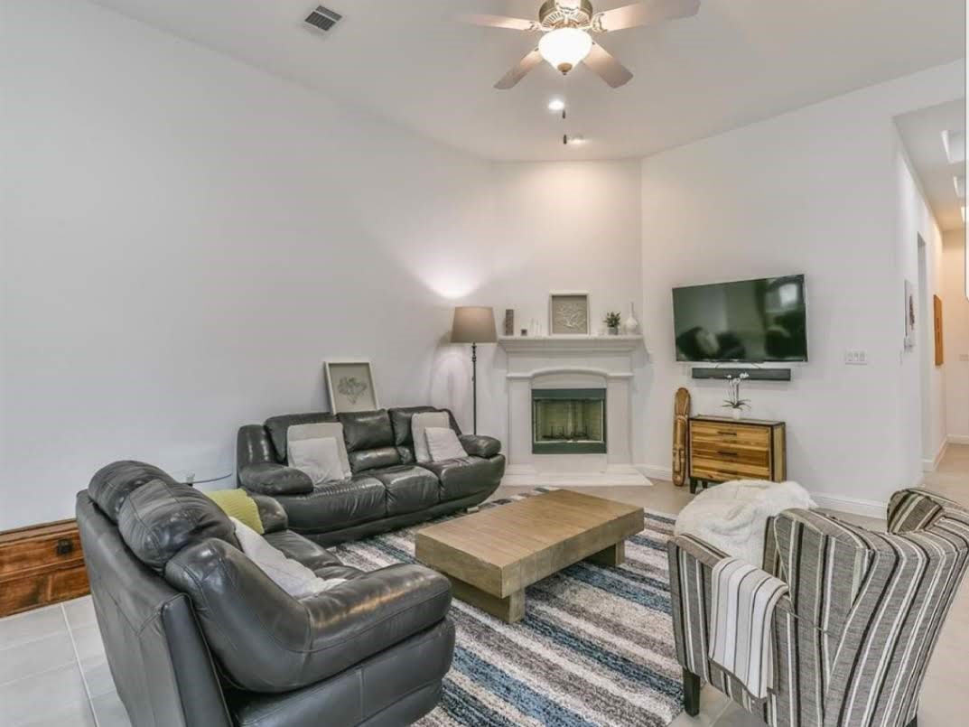 13326 Lake Chesdin Road Houston, TX 77044 - Photo 10 of 23 a living room with furniture a fireplace and a flat screen tv