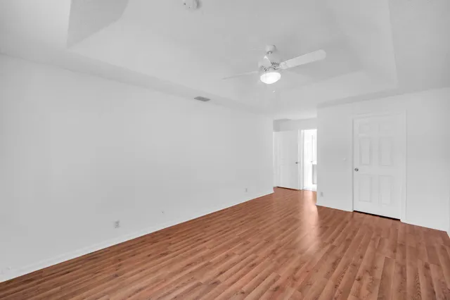 a view of an empty room with wooden floor