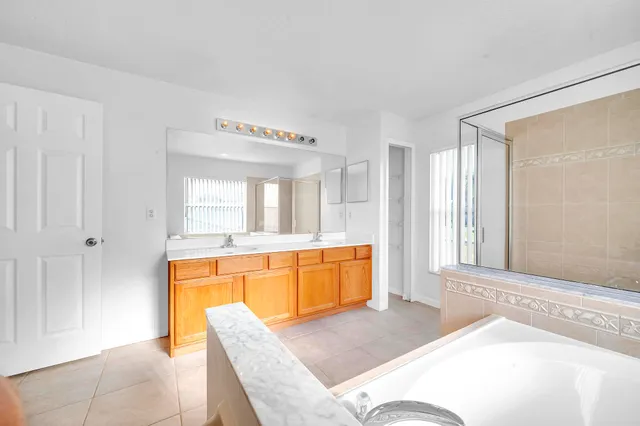 a spacious bedroom with a large window and a tub