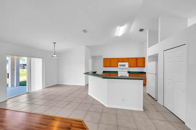 a view of kitchen with stainless steel appliances granite countertop a stove and a sink
