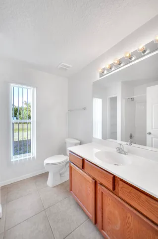 a bathroom with a sink a toilet and a window