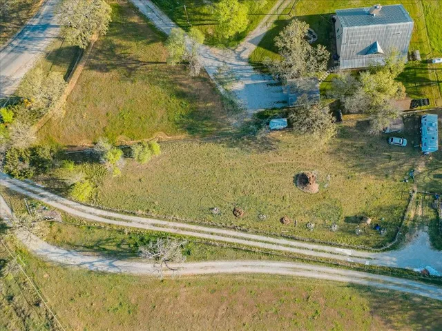 an aerial view of residential houses with outdoor space and trees