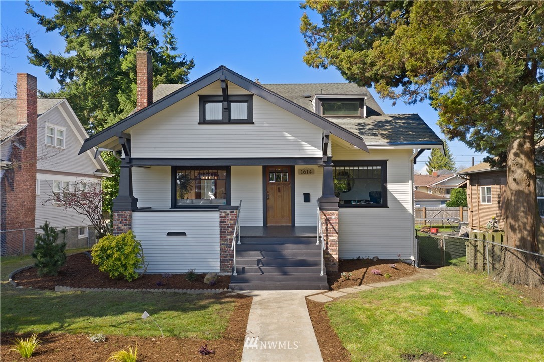 a front view of house with yard and trees in the background