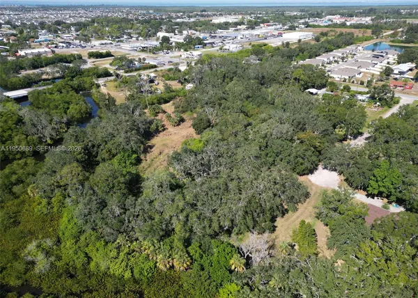 an aerial view of residential houses with outdoor space and trees