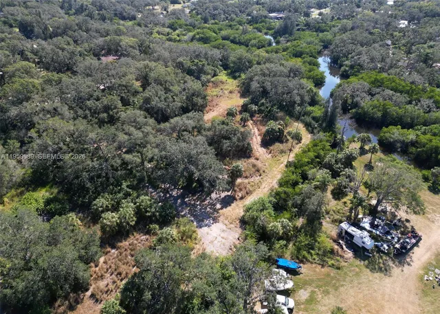 an aerial view of residential house with outdoor space and trees all around
