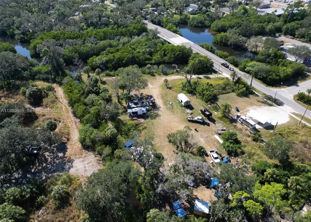 an aerial view of residential house with green space and fog