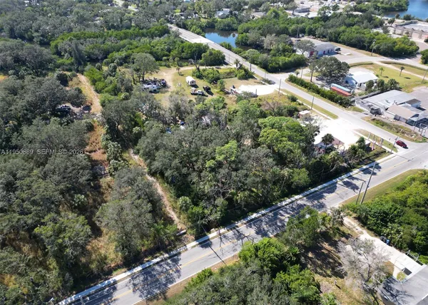 an aerial view of residential house with outdoor space and trees all around