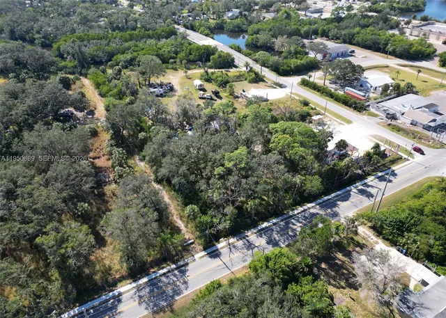 an aerial view of residential house with outdoor space and trees all around