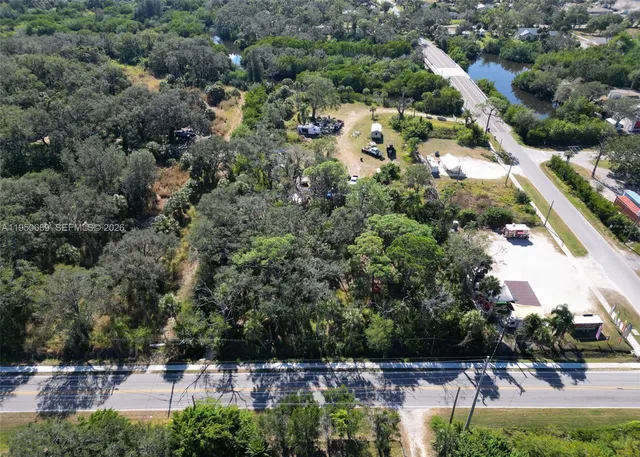 an aerial view of residential houses with outdoor space and trees