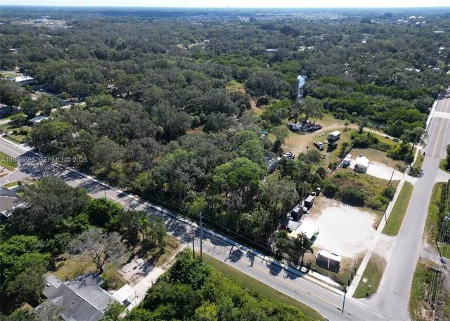 an aerial view of a houses with a yard and lake view