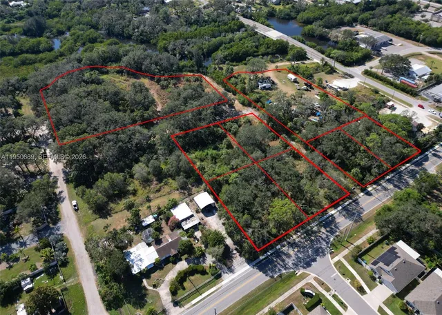 an aerial view of residential houses with outdoor space and trees
