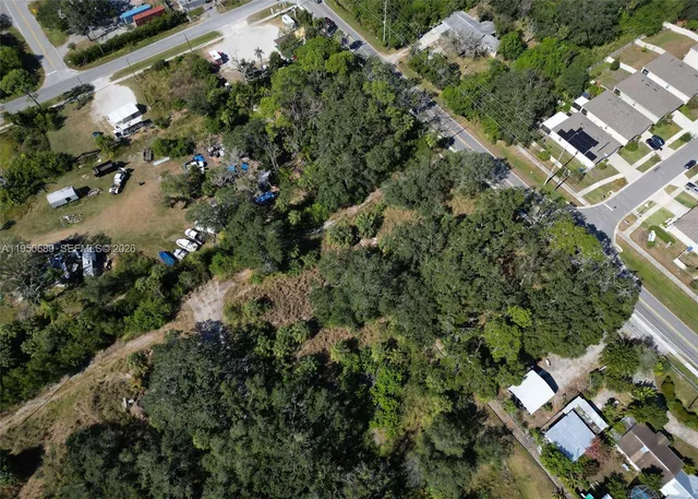 an aerial view of residential houses with outdoor space and trees all around