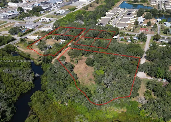 an aerial view of residential houses with outdoor space and trees