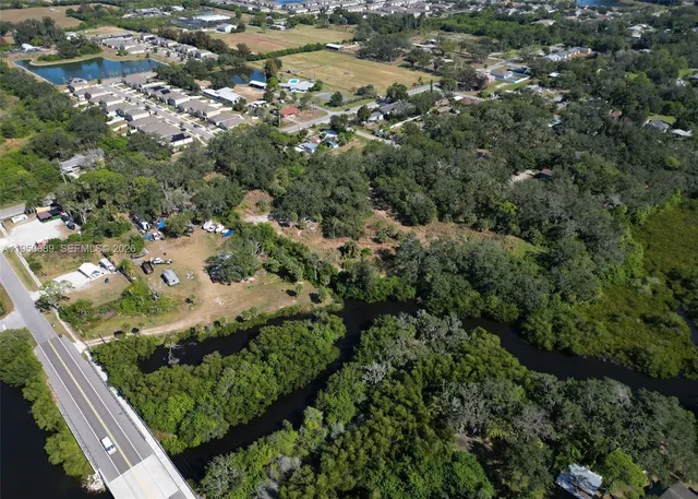 an aerial view of residential houses with outdoor space and trees