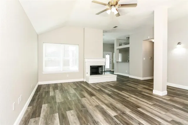 a view of an empty room with a fireplace and a window