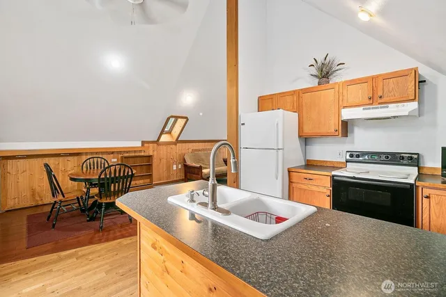 a kitchen with stainless steel appliances granite countertop a sink and a refrigerator