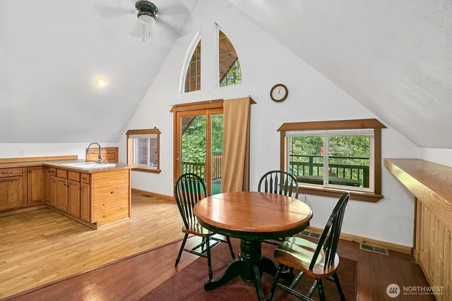 a kitchen with stainless steel appliances granite countertop a stove a sink a dining table and chairs