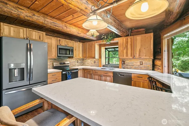 a kitchen with stainless steel appliances granite countertop a sink window and cabinets