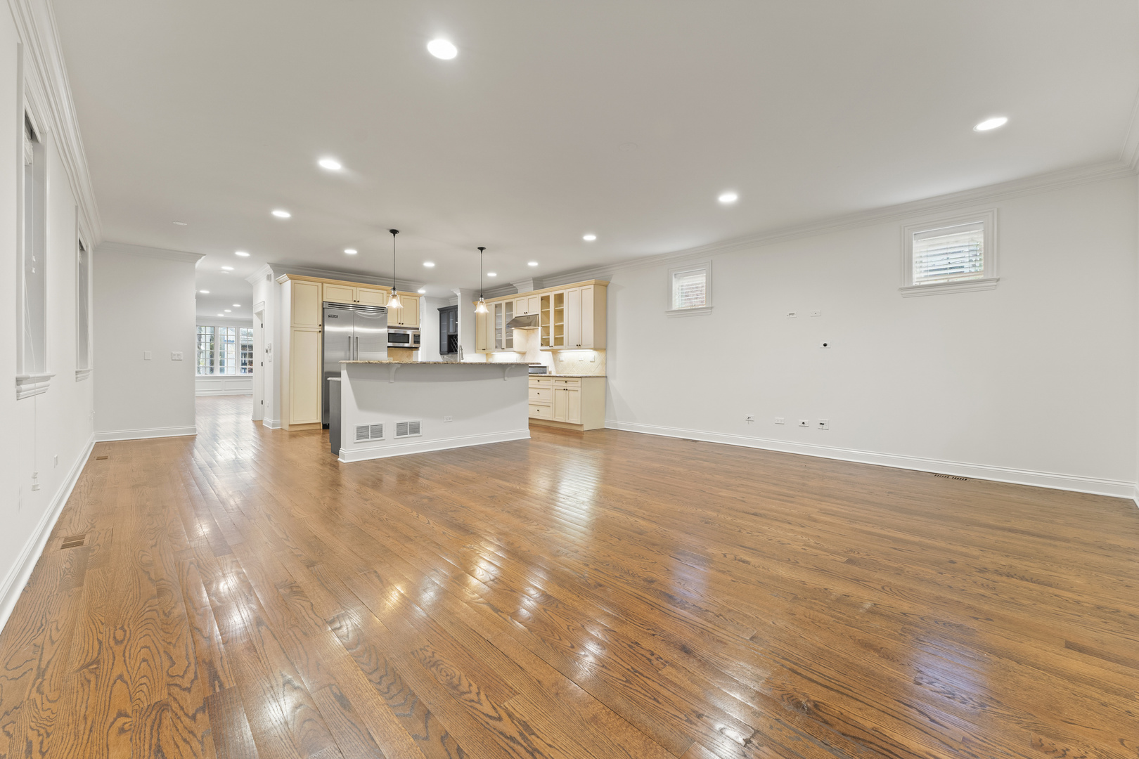 3716 North Kenmore Avenue, Unit 1 Chicago, IL 60613 - Photo 14 of 33 a view of a kitchen with kitchen island a sink wooden floor and a refrigerator